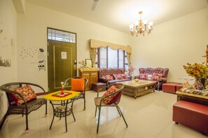 A living room with a sofa set, a coffee table, and a dining table with chairs.