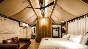 A tented room with a bed, a sofa, and a ceiling fan. - Lala Mukha Tented Resort Khao Yai (Pak Chong)