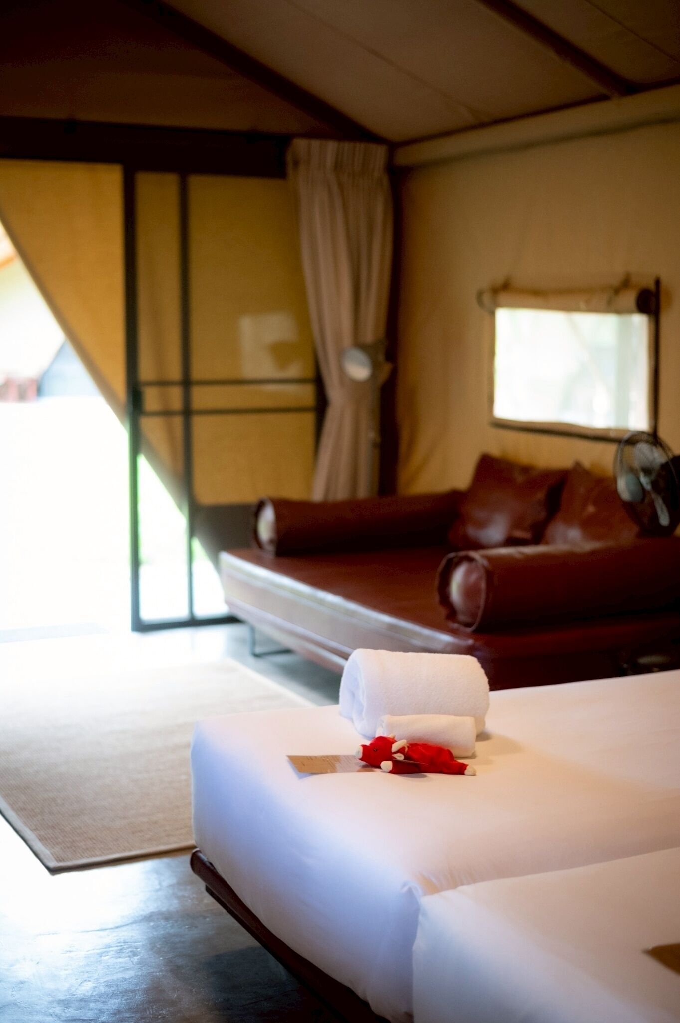Una habitación de hotel con cama, sofá, ventilador y ventana.