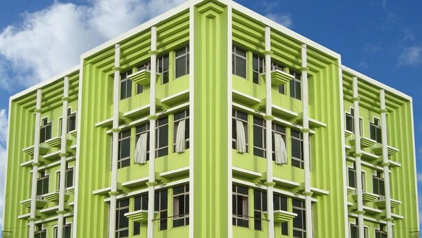 A green building with a symmetrical facade, multiple windows, and balconies. - The Sincro Hotel (Margao)