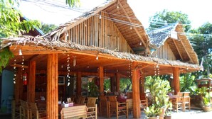 A wooden structure with a thatched roof, bamboo furniture, and hanging lights. - Baan Kuasakul Resort (Koh Samui)