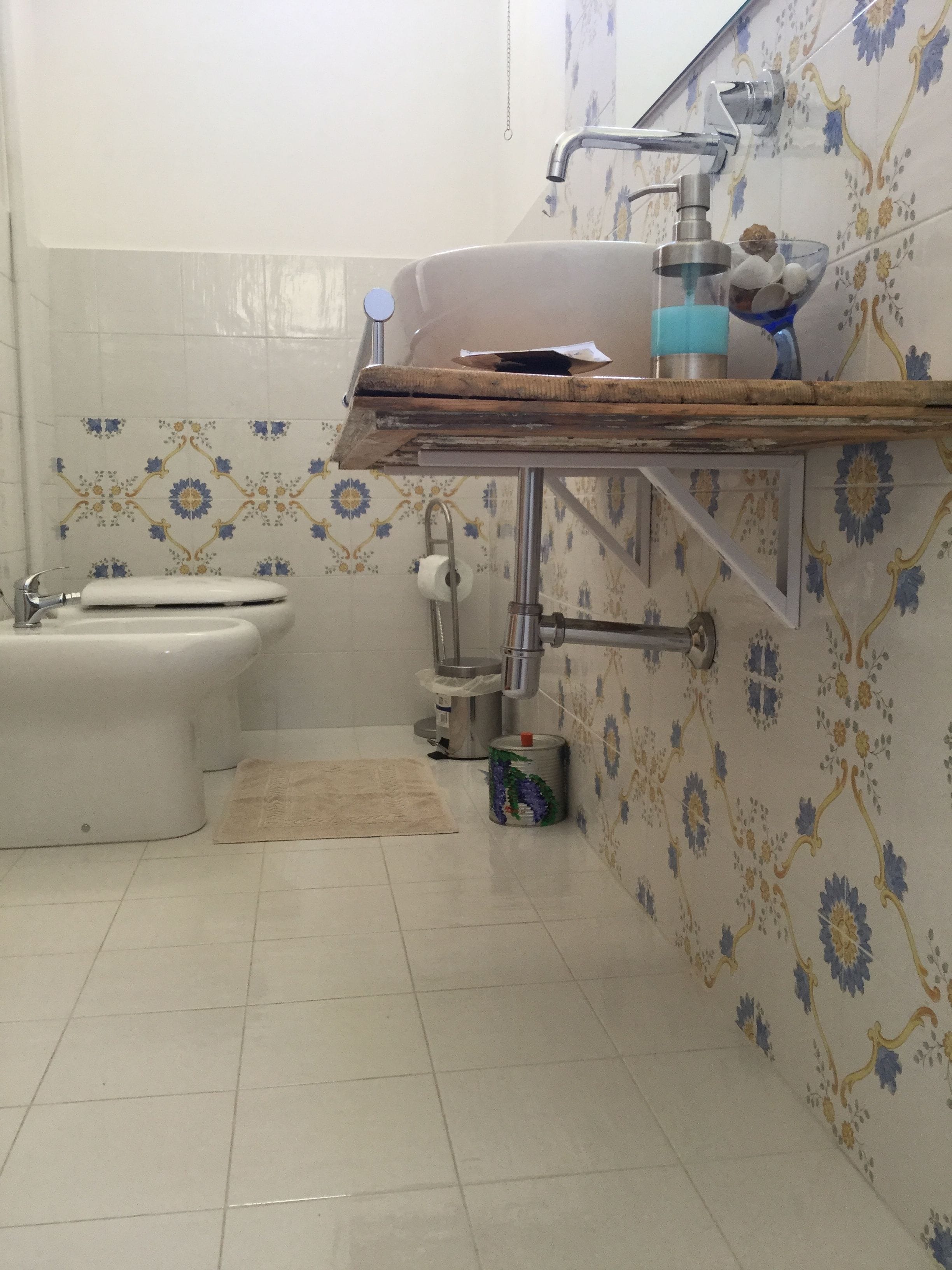 Een badkamer met toilet, wastafel en hygiëneschuimer.