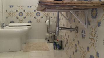 Een badkamer met toilet, wastafel en hygiëneschuimer.