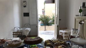 Ein Essbereich mit einem gedecktem Tisch, einer Kuchenauslage und verschiedenen Desserts.