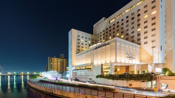 Un hotel con fachada moderna, amplias ventanas y vista al agua.