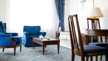 A room with a blue armchair, a wooden coffee table, and a lamp.