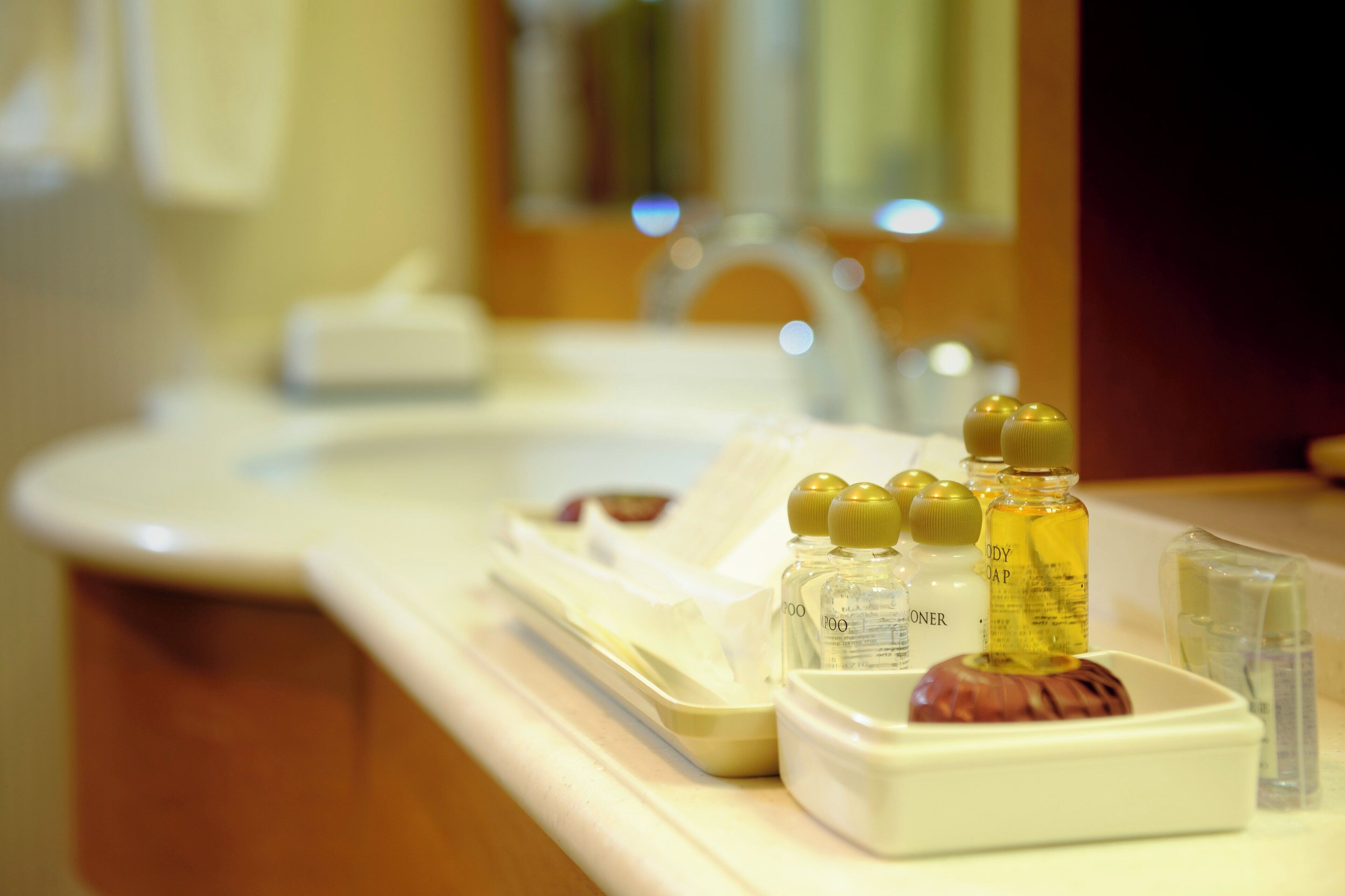 A bathroom counter with toiletries including bottles of shampoo, body wash, and a razor.