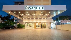 The exterior of Nanotel hotel with a modern design, a well-lit entrance, and a paved driveway. - Nanutel Margao (Margao)