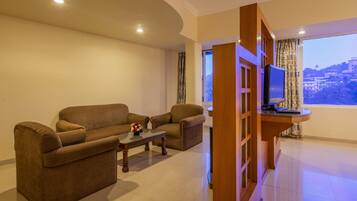 Una sala de estar con dos sofás, una mesa de centro y un televisor sobre un mueble de madera.
