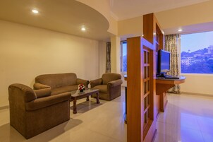 Una sala de estar con dos sofás, una mesa de centro y un televisor sobre un mueble de madera.