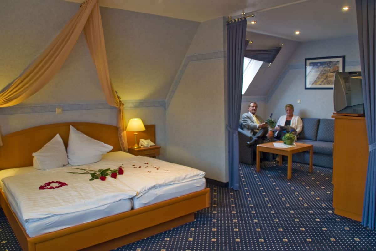Une chambre d’hôtel comprenant un lit, un coin salon et un téléviseur.
