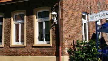 A brick building with multiple windows and a sign that reads "Biergarten".