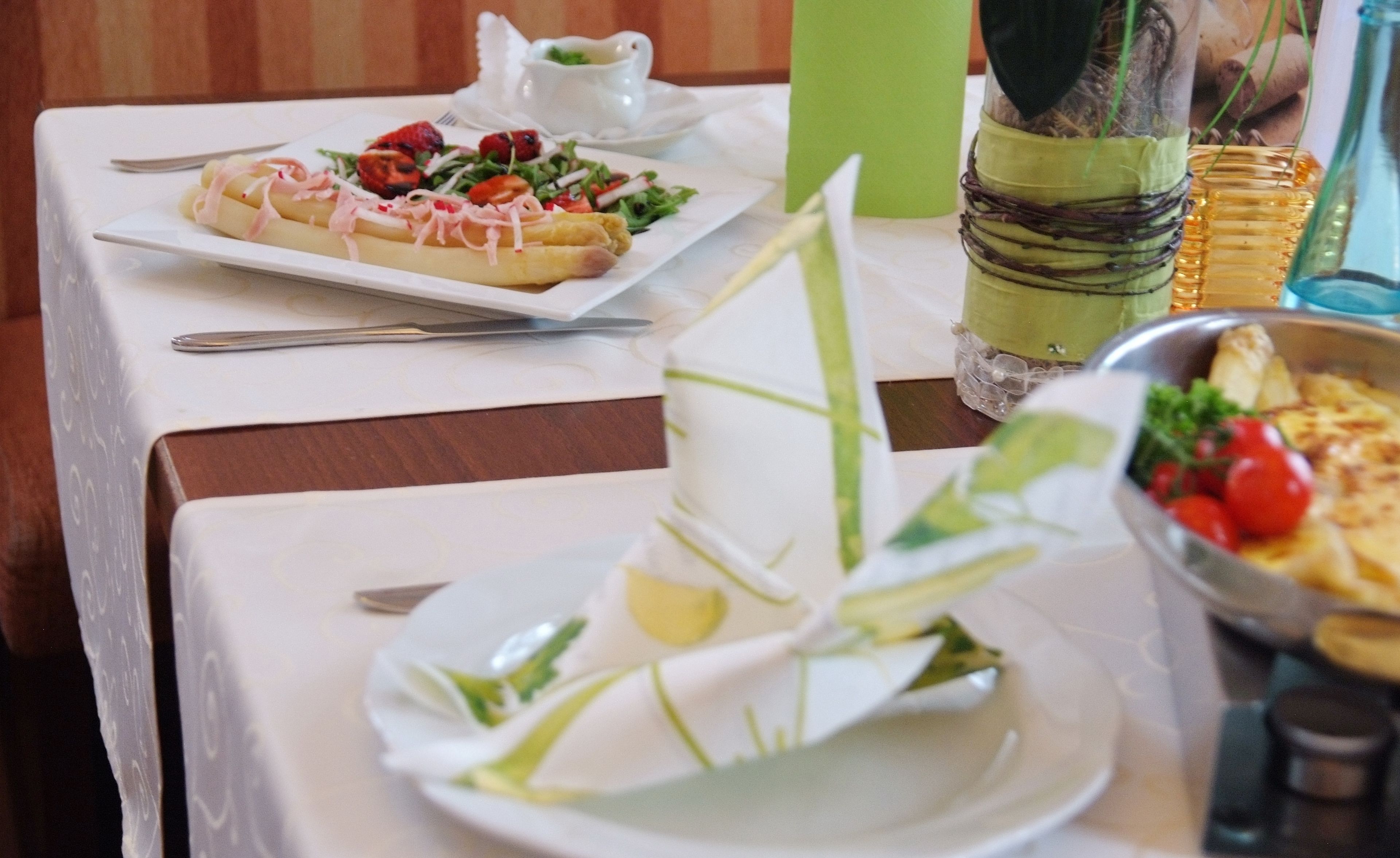 A dining table with a plate of food, a pitcher, and a decorative plant.
