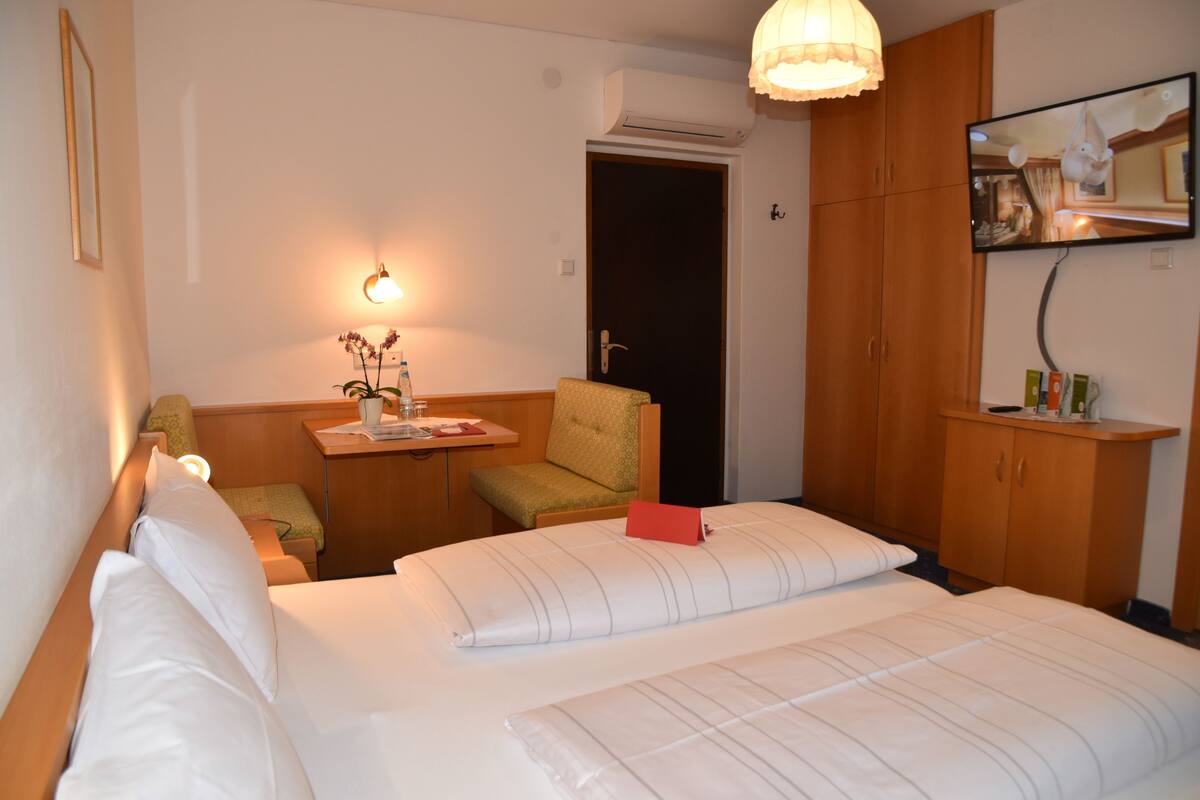 Une chambre d’hôtel équipée d’un lit, d’un bureau, d’une chaise, d’une télévision et d’une armoire.