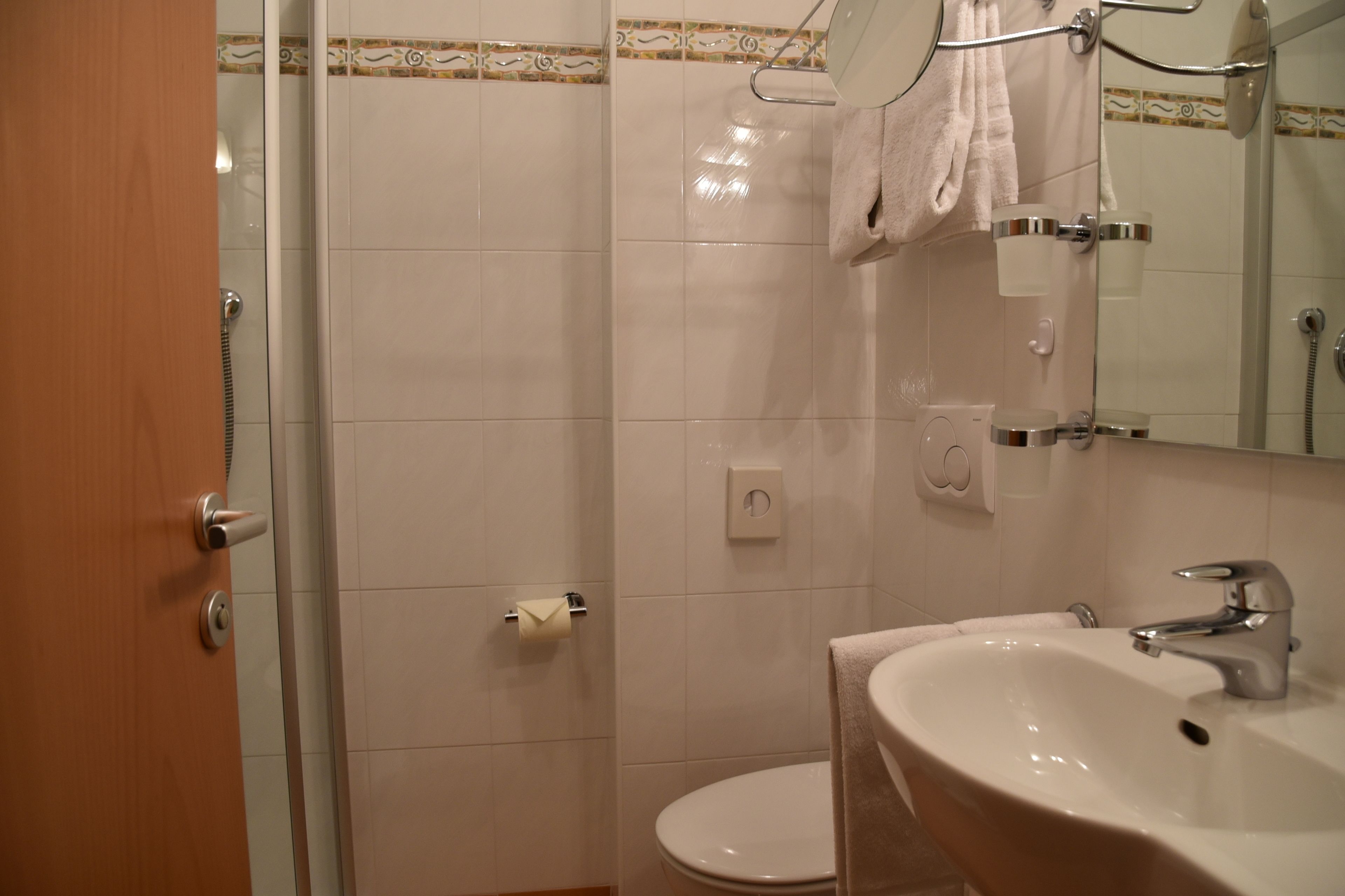 A bathroom with a toilet, sink, and shower.