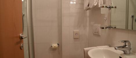 A bathroom with a toilet, sink, and shower.