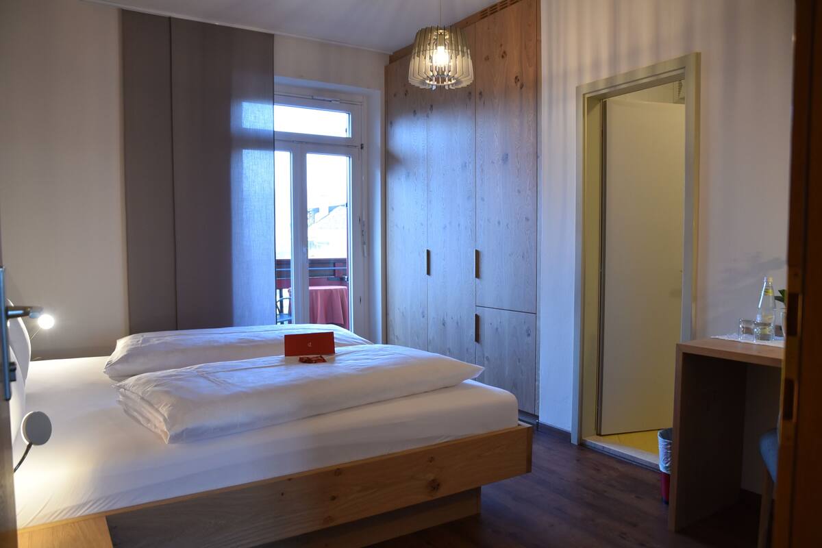 Une chambre à coucher avec un grand lit, une armoire en bois et un bureau avec une chaise.