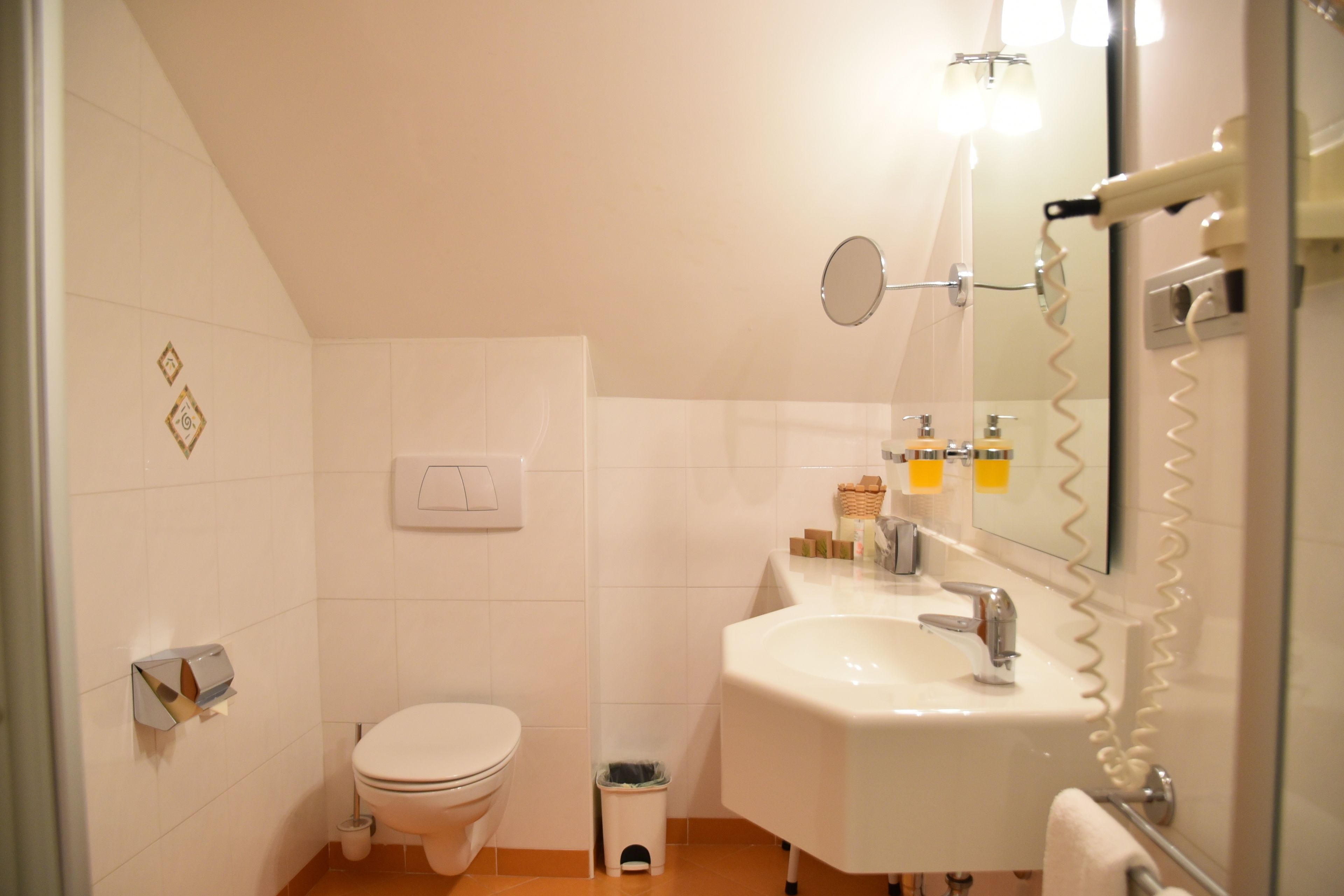 Ein Badezimmer mit Toilette, Waschbecken und Spiegel.