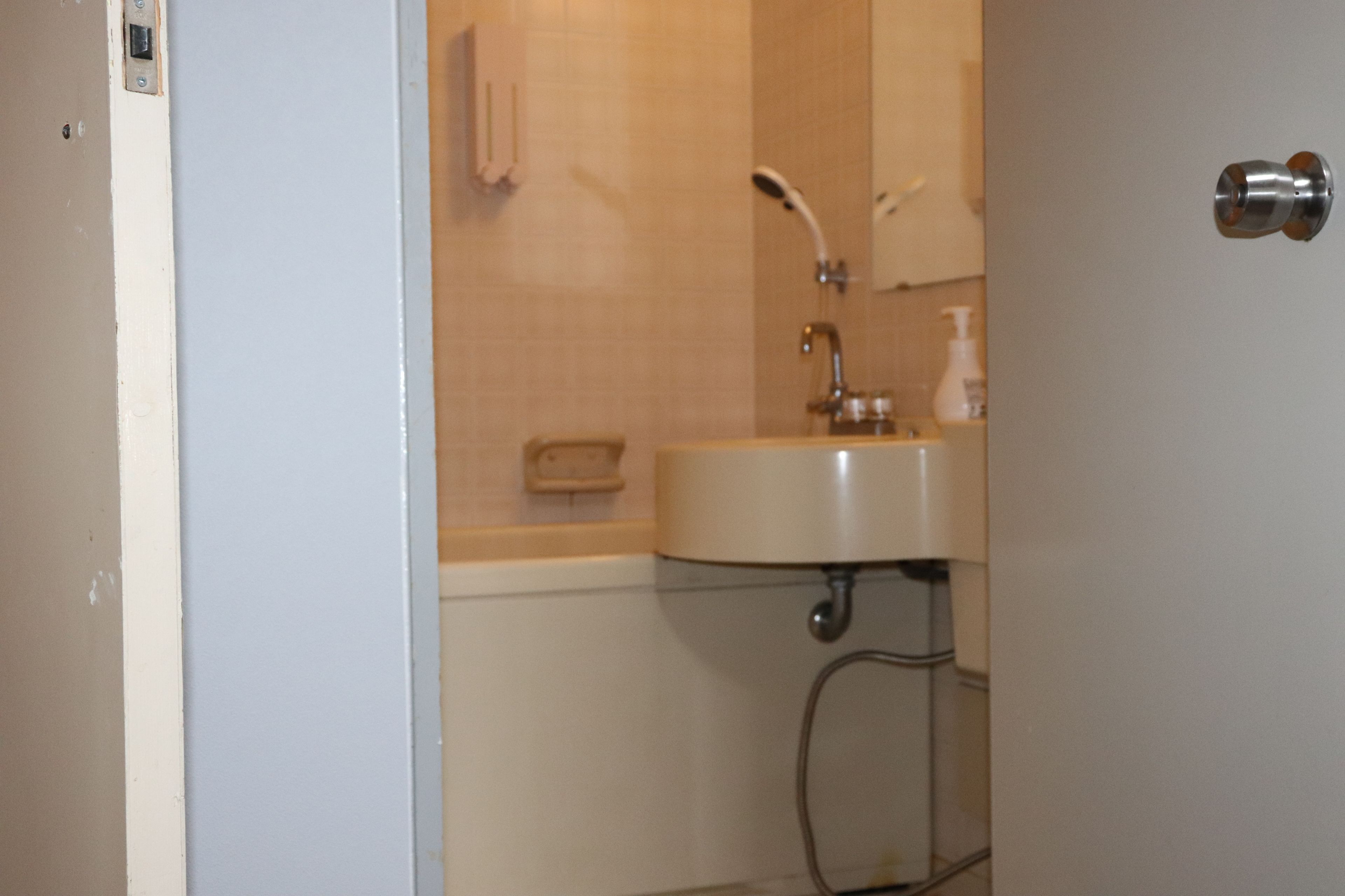A bathroom with a sink, mirror, and towel rack.