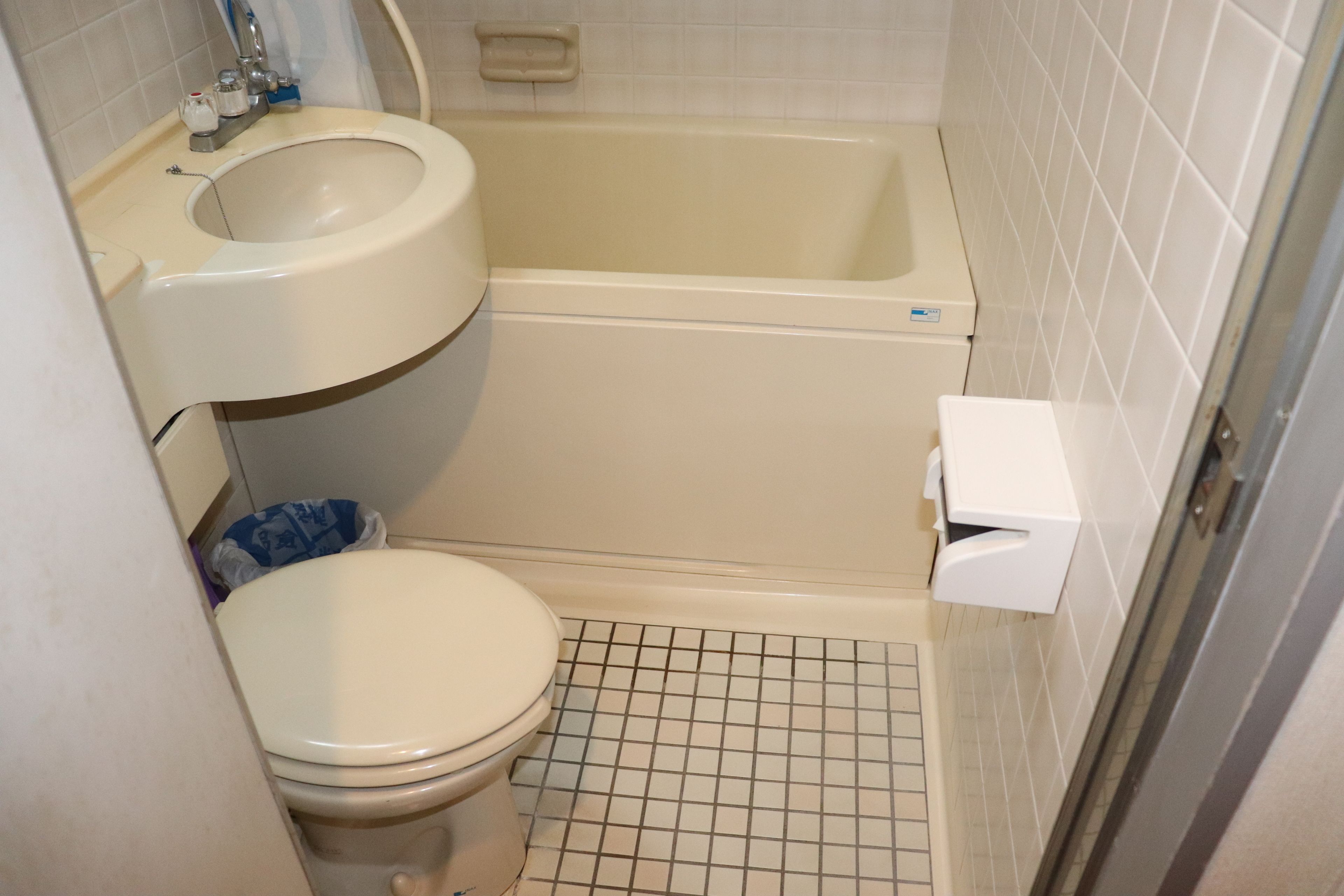 A bathroom with a toilet, sink, and bathtub.
