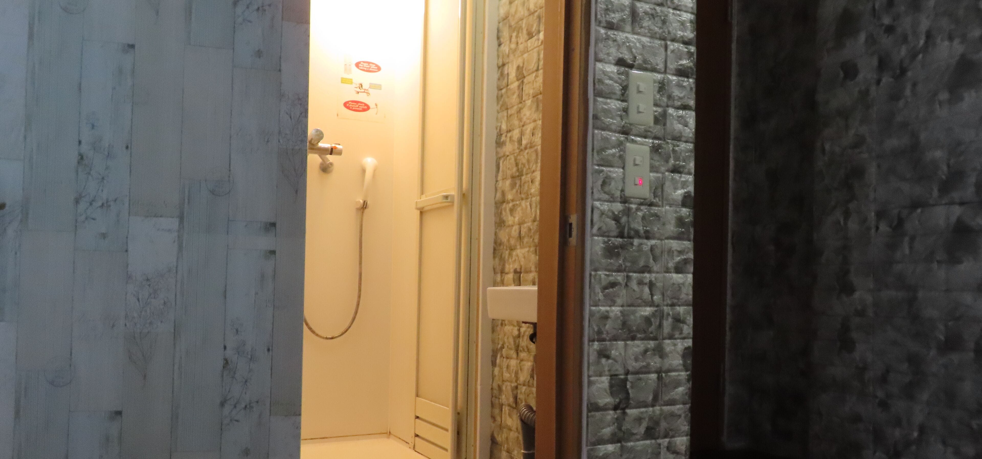 A bathroom with a shower, a toilet, and a sink.