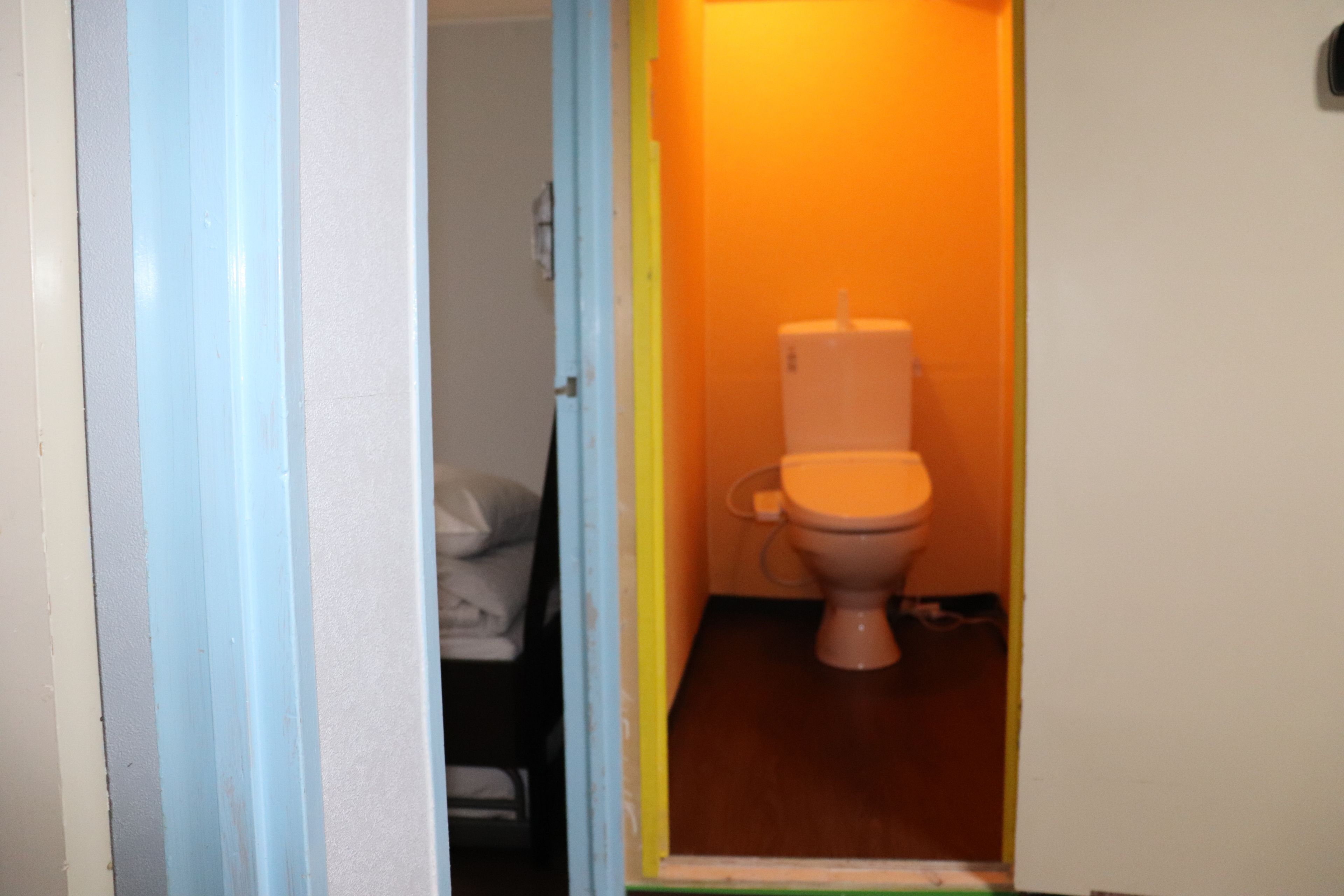 A small bathroom with a toilet, a sink, and a shower area.