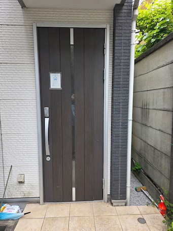 A closed sliding door with a keypad lock, a small sign above it, and a tiled entrance area.