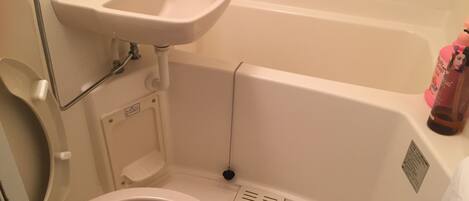 A bathroom with a toilet, sink, and bathtub.