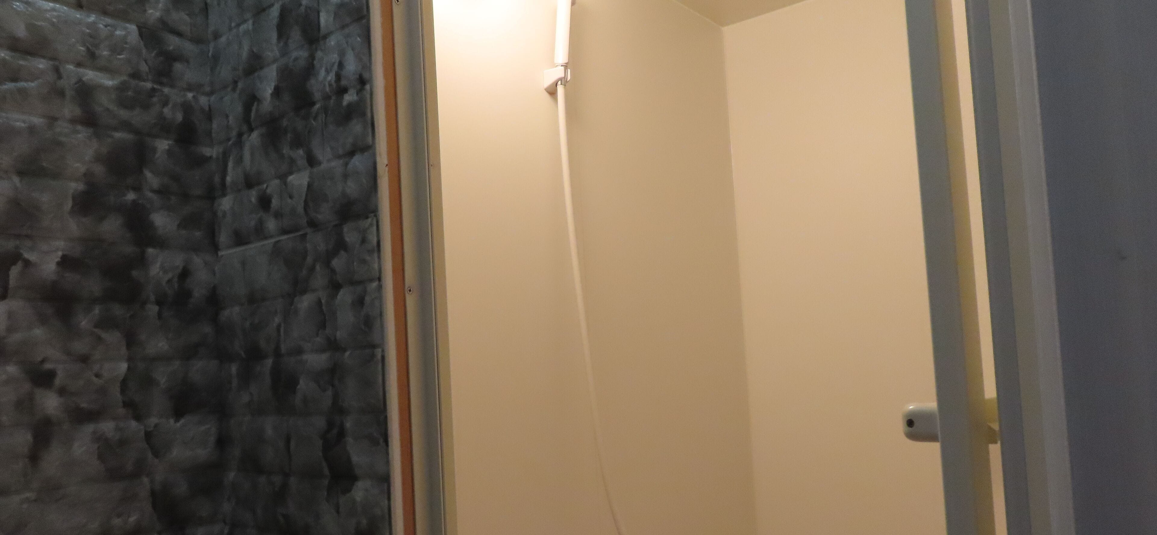 A bathroom with a stone wall and a beige door.