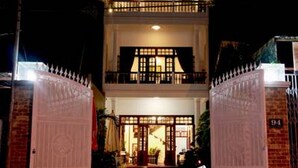 A two-story building with a balcony and a gated entrance. - Green Grass Homestay (Hoi An)