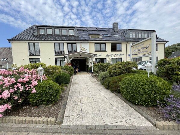 A two-story building with a sign reading "Leine Perle Wellness." - Aparthotel kleine Perle (Cuxhaven)