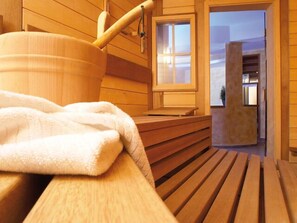 Un cuarto de sauna con bancos de madera y un banco con toalla.