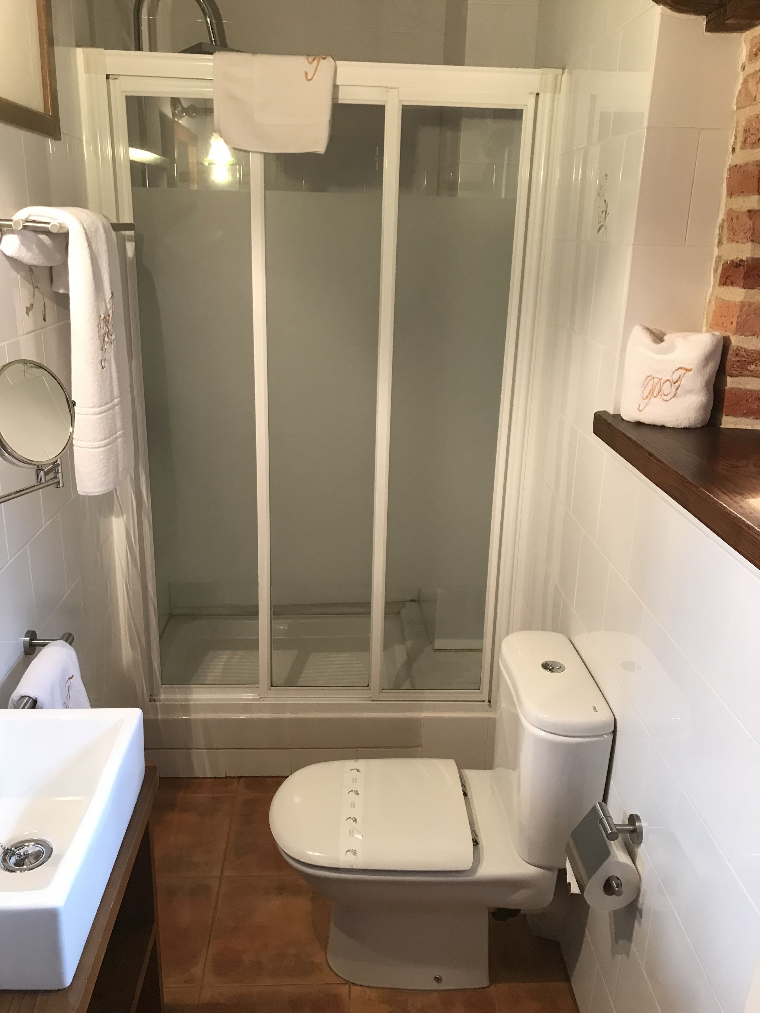 Et badeværelse med brusekabine, toilet og vask.