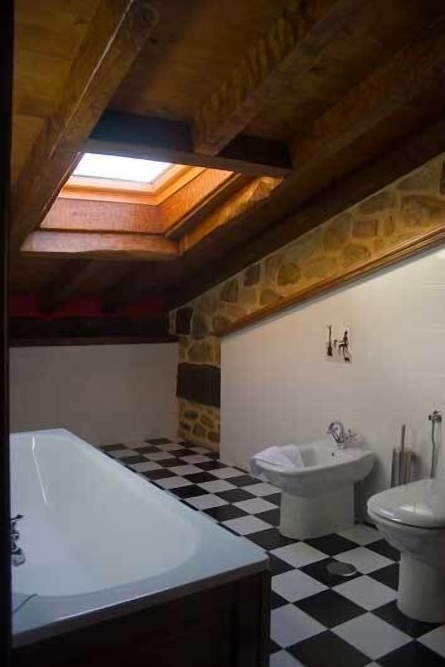Un baño con piso a cuadros, una bañera, un lavamanos y un inodoro.