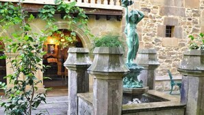 A courtyard with stone walls, a fountain, and outdoor seating. - Hotel Palacio de Trasvilla (Villafufre)