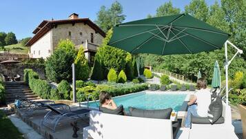 Een buitenzwembad en ligstoelen