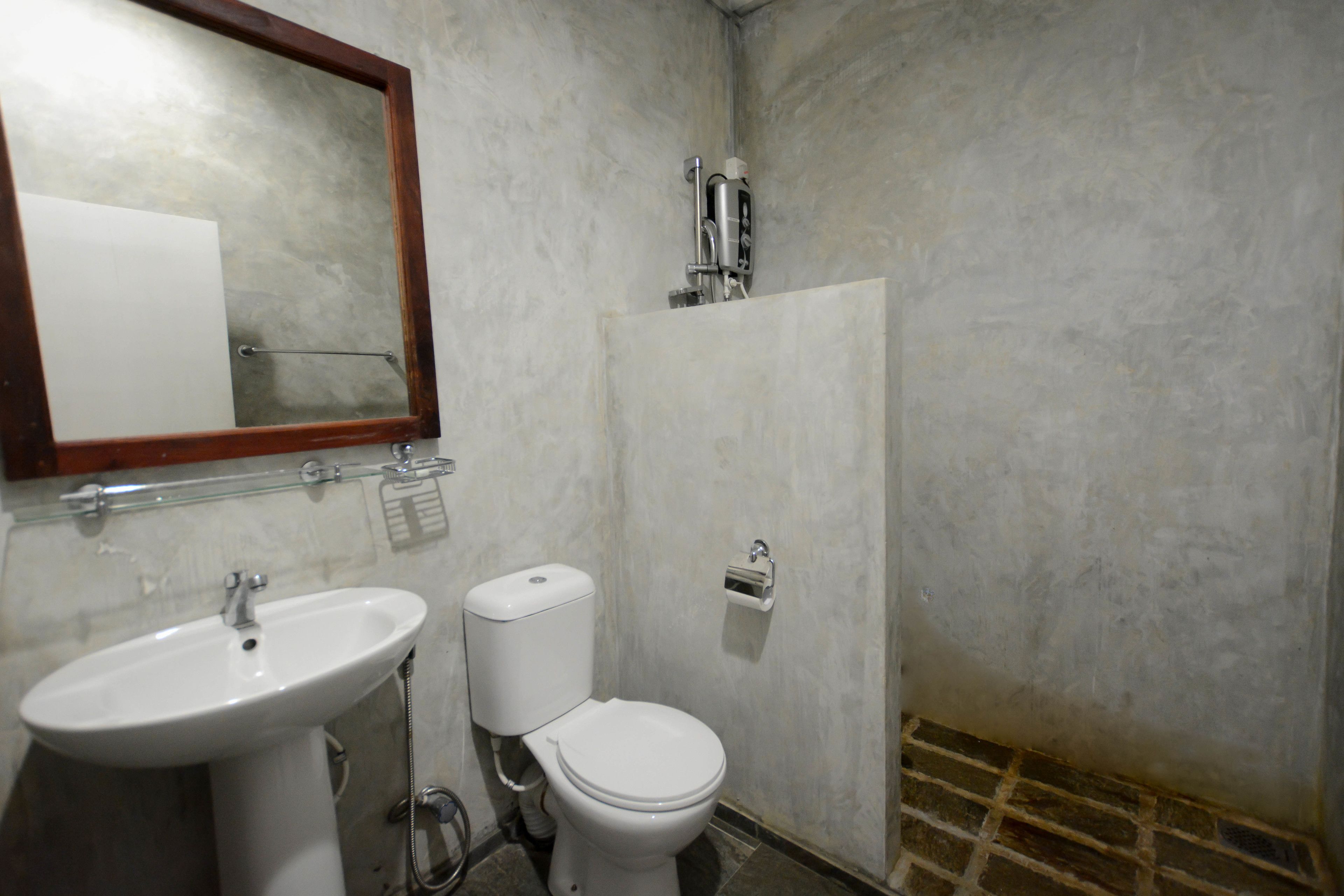 A bathroom with a sink, toilet, and mirror.