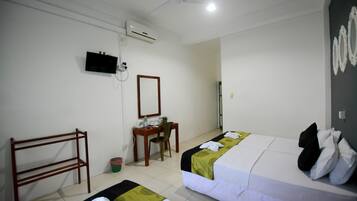 Habitación de hotel con dos camas, un escritorio, una silla, un televisor y un aire acondicionado.