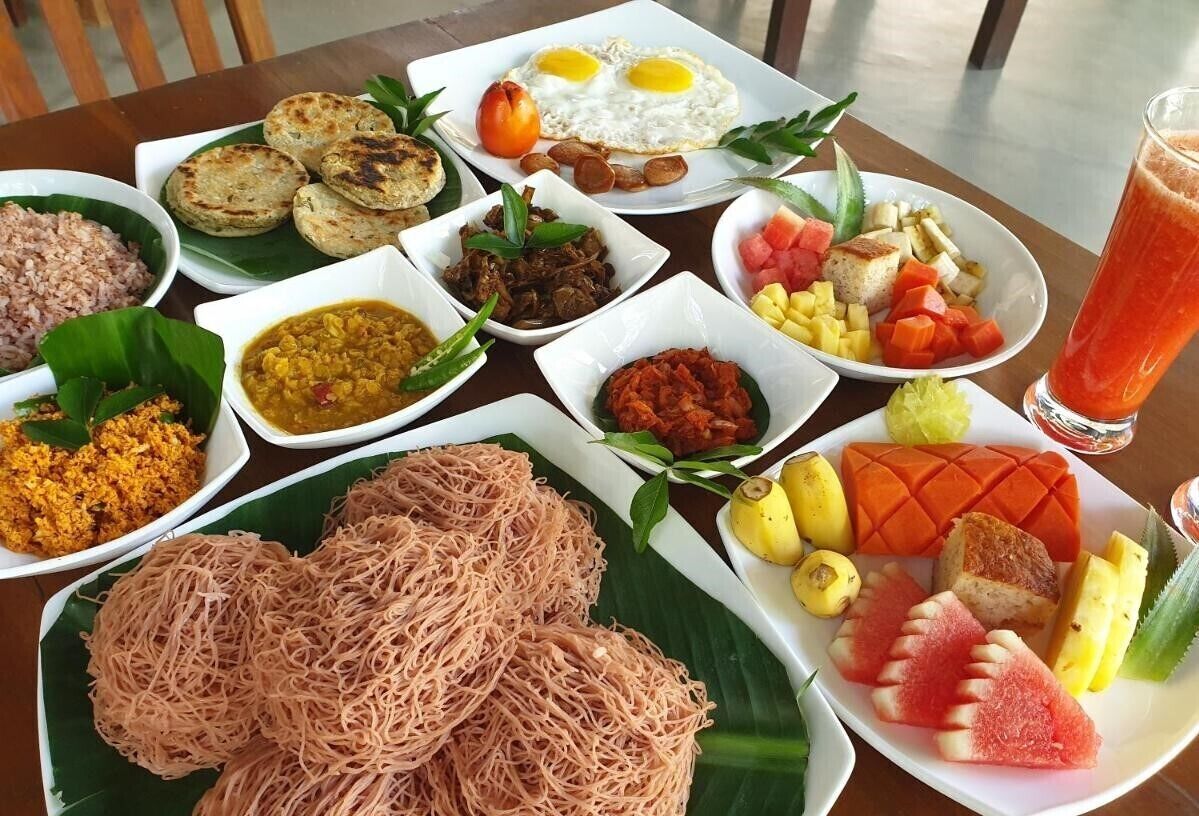 A table with various dishes including fried eggs, rice, and a variety of vegetables.