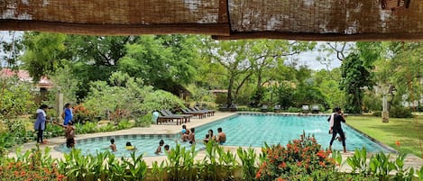 Una piscina al aire libre, sillones reclinables de piscina