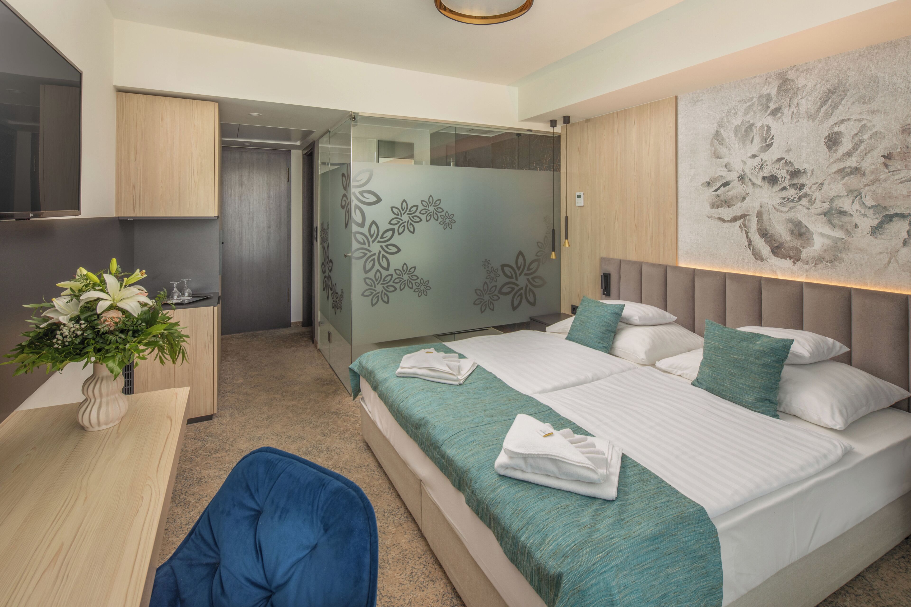 A modern bedroom with a large bed, a desk, and a chair.