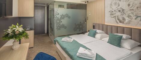 A modern bedroom with a large bed, a desk, and a chair.