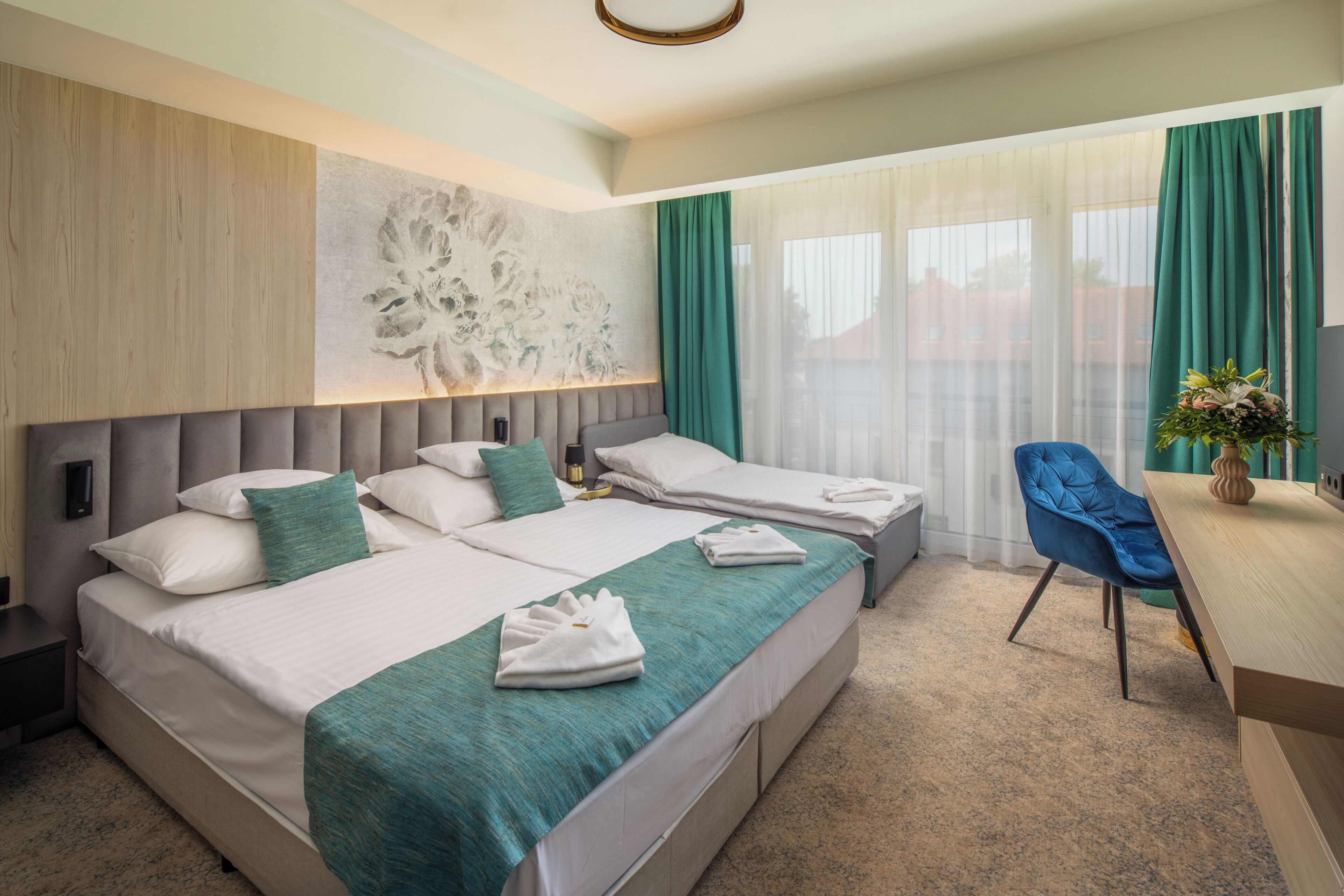 Una habitación de hotel con una cama grande, dos mesitas de noche, un escritorio y una silla.