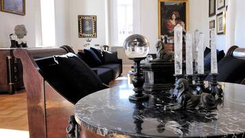 Un comedor con una mesa de mármol, sillas negras y candelabros de cristal.