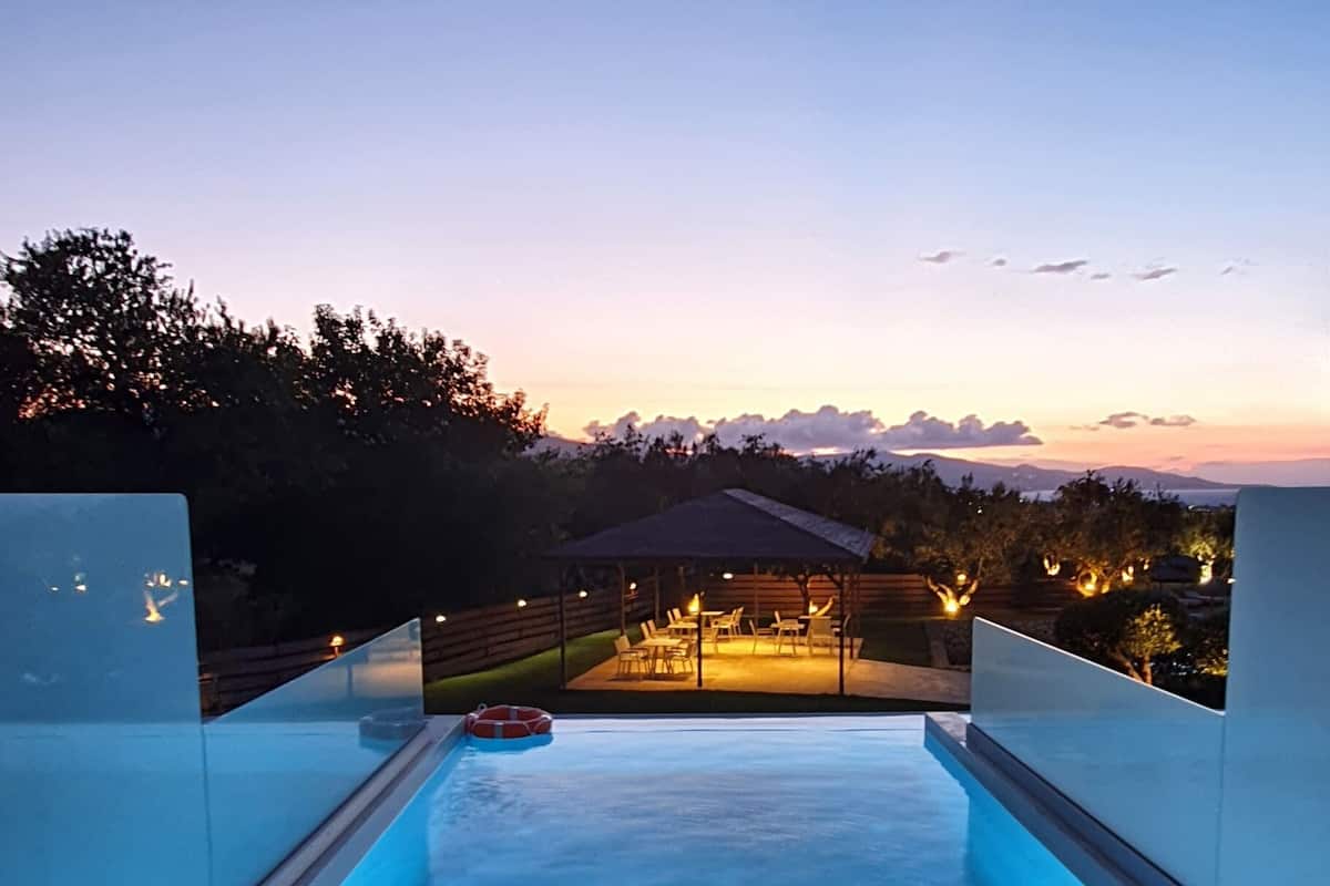 A swimming pool with a view of the mountains at dusk.