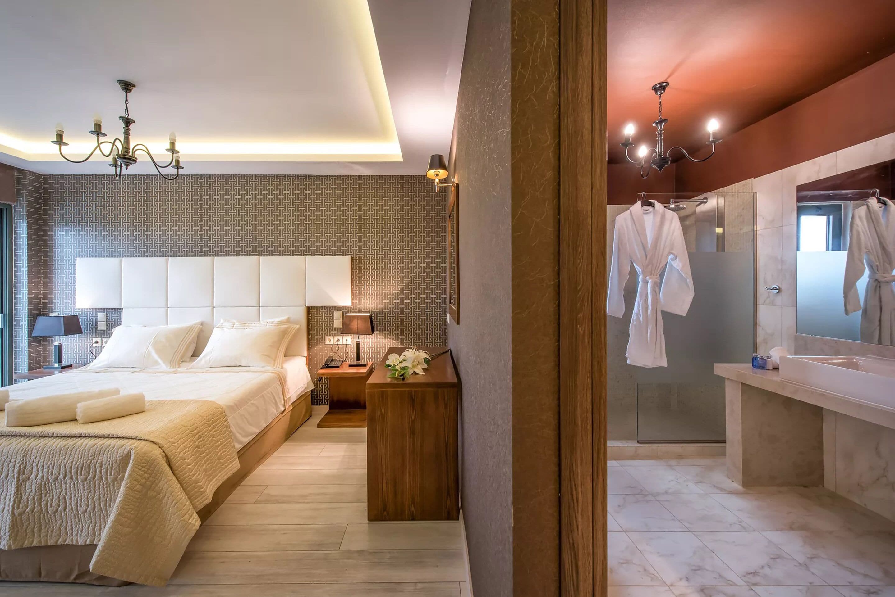 A modern hotel room with a large bed, bedside table, lamp, and a view of the bathroom.