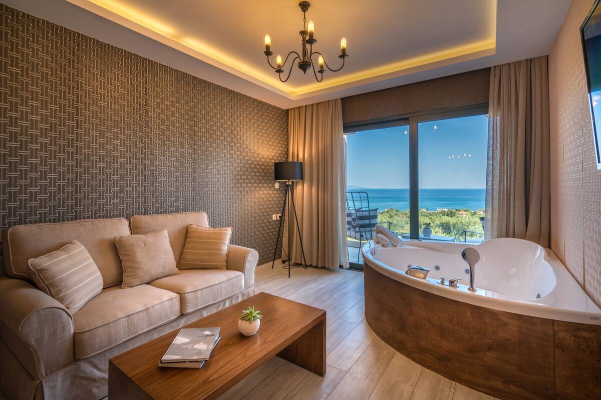 A modern living room with a sofa, coffee table, and a large bathtub.