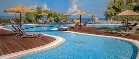 Outdoor pool, an infinity pool, pool umbrellas, sun loungers