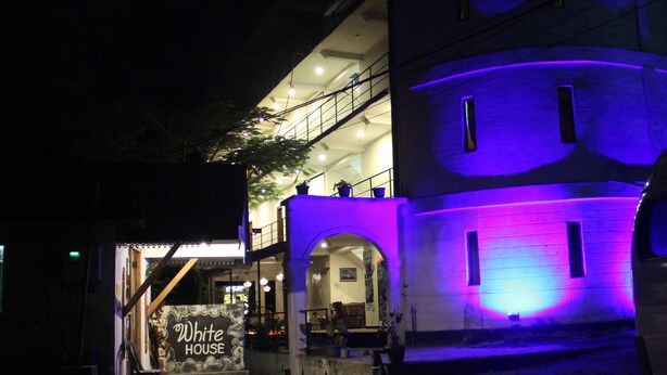 A building with a sign reading "White House" at the entrance, featuring a staircase and a balcony with railings. - White House Adam's Peak (Nallathanniya)