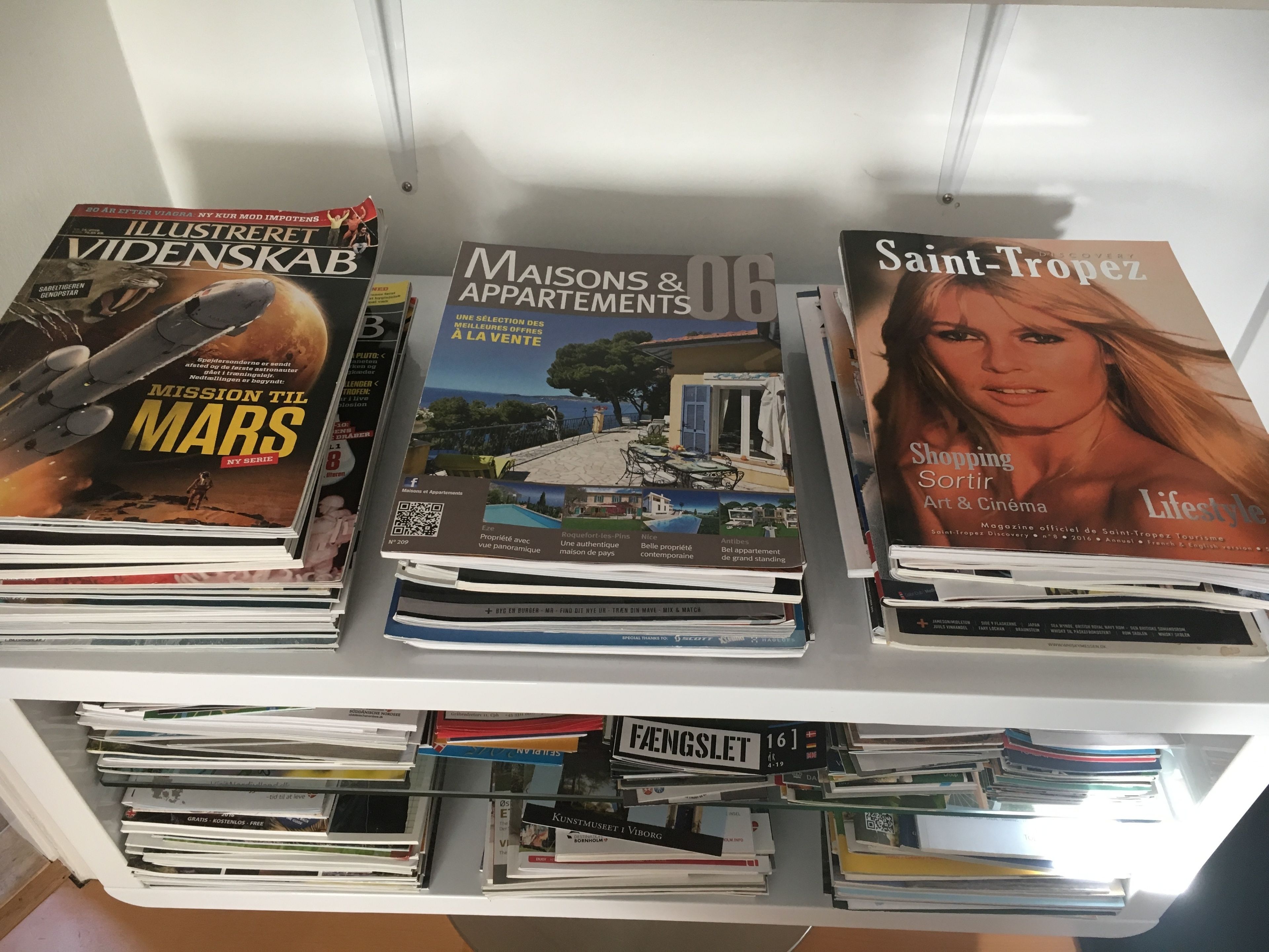 A bookshelf with various magazines, including 'Illustreret Videnskab', 'Maisons & Appartements', and 'Saint-Tropez'.